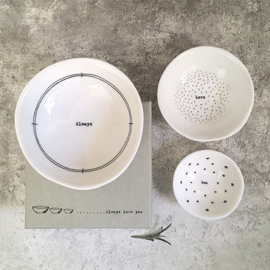 Set of white ceramic bowls with text on a gray surface