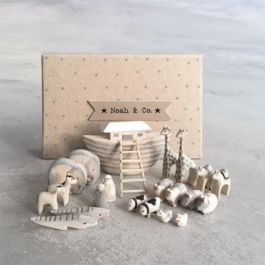 Wooden toy set with Noah's Ark and animals on a gray surface, branded 'Noah & Co'.