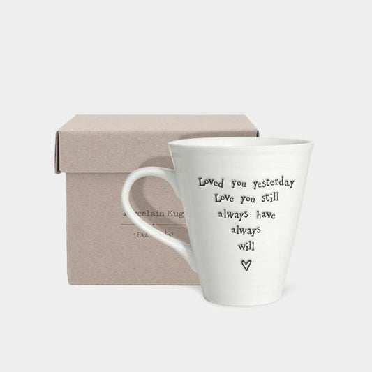 White mug with text and heart design in a gift box on a light gray background