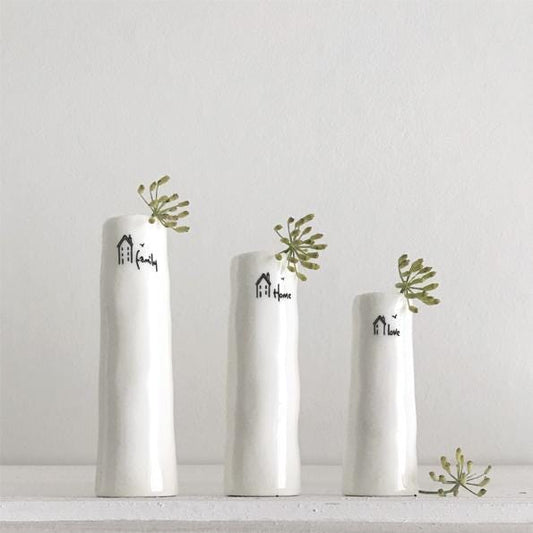 Three white vases with decorative text and greenery on a light gray background