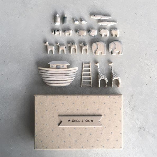 Set of ceramic toys including a boat, animals, and a ladder on a textured surface with 'Noah & Co.' branding.