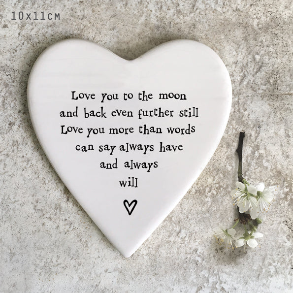 Heart-shaped plaque with romantic message on a textured surface