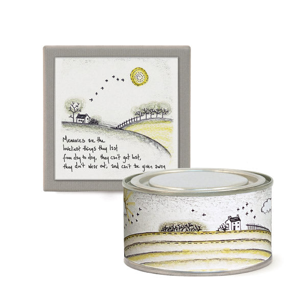 Decorative tin with landscape design and framed artwork on a white background