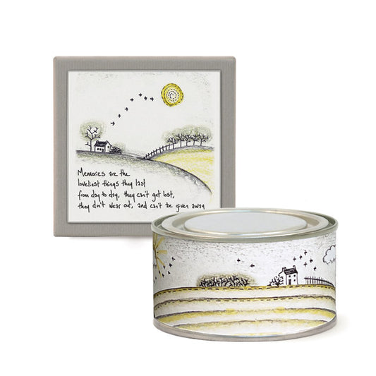 Decorative tin with landscape design and framed artwork on a white background