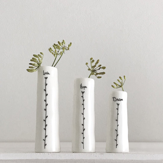 Three white vases with plant stems and text on a light gray background