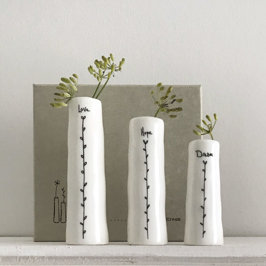 Three white vases with text and plant designs on a neutral background
