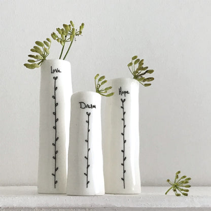 Three white vases with greenery and text on a light gray background