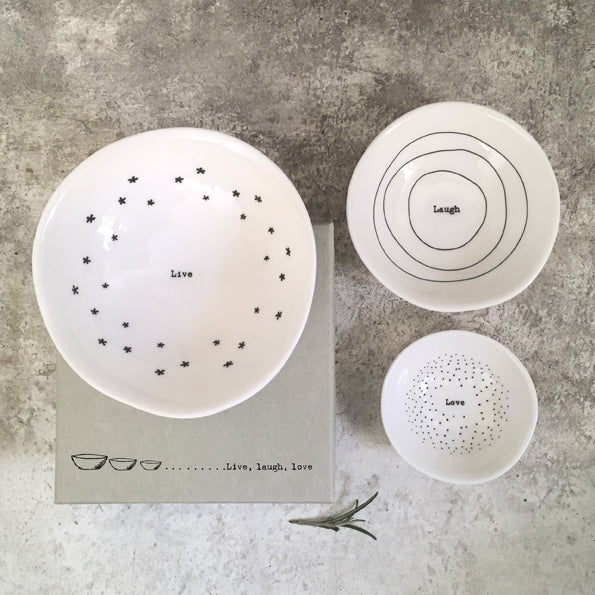 Set of ceramic bowls with motivational phrases on a textured surface