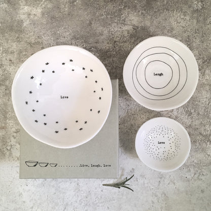 Set of ceramic bowls with motivational phrases on a textured surface