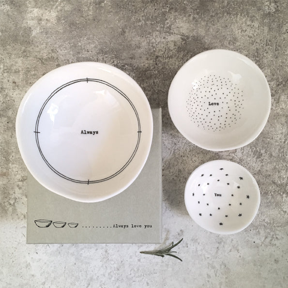 Set of white ceramic bowls with text on a gray surface