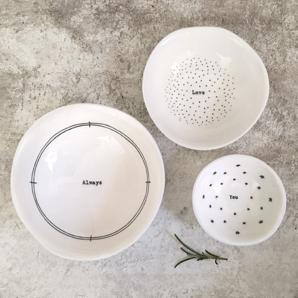 Three white bowls with text on a gray surface