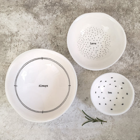Three white bowls with text on a gray surface