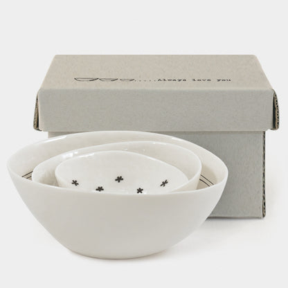 Set of white ceramic bowls with decorative elements on a light gray background