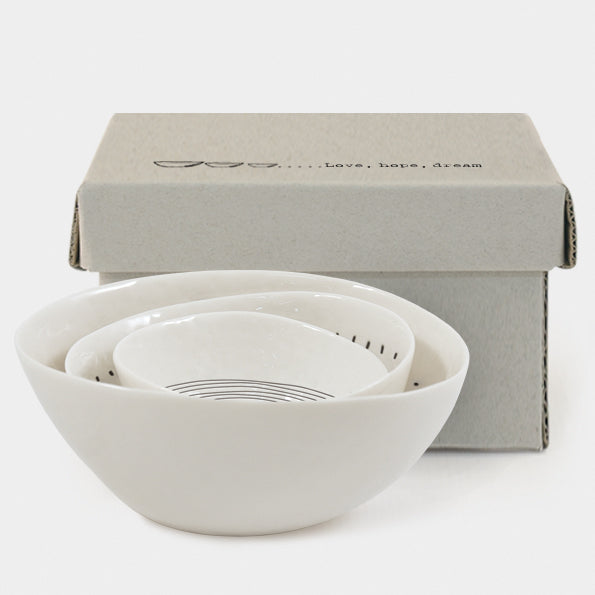 Set of white ceramic bowls with a matching box on a white background
