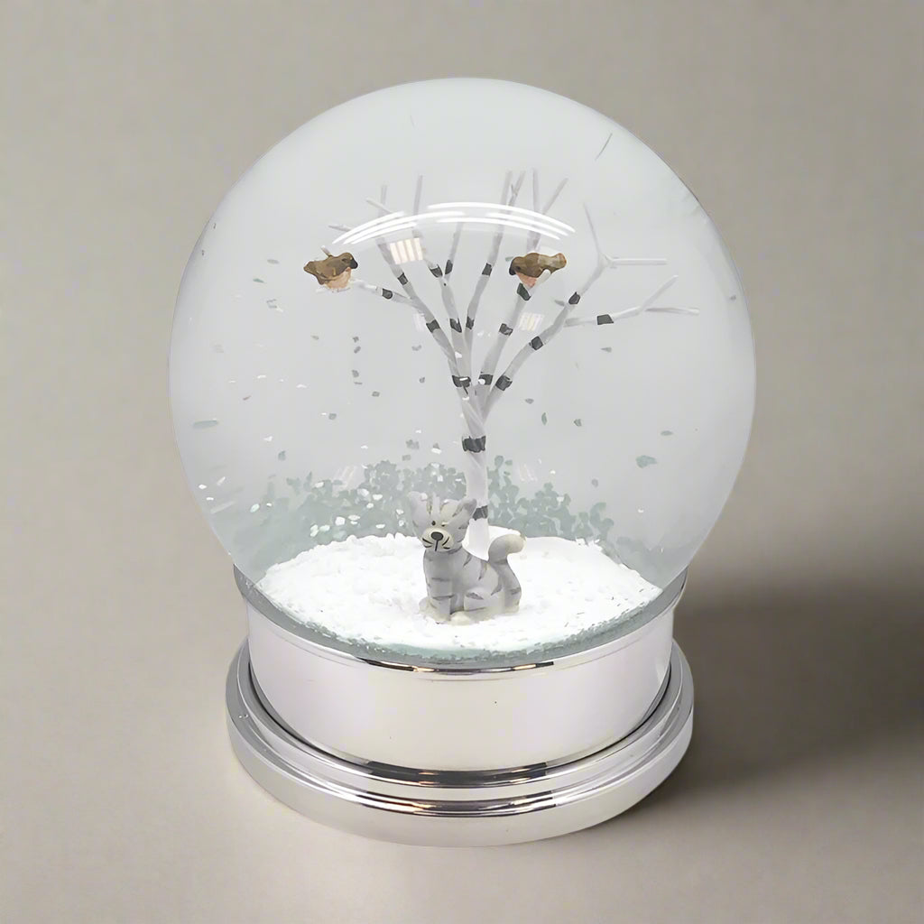 Snow globe with a tree and animal figure inside on a white background