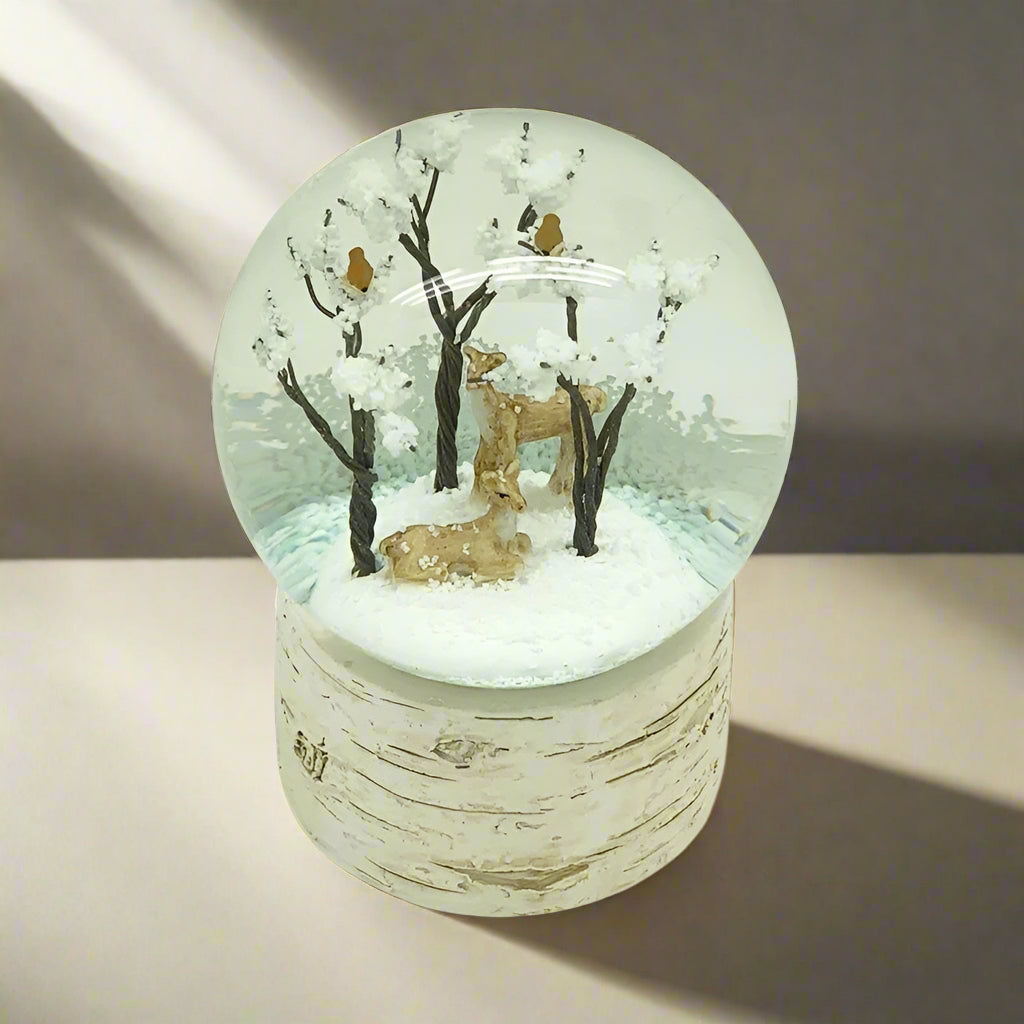 Snow globe with deer and trees inside, on a white background
