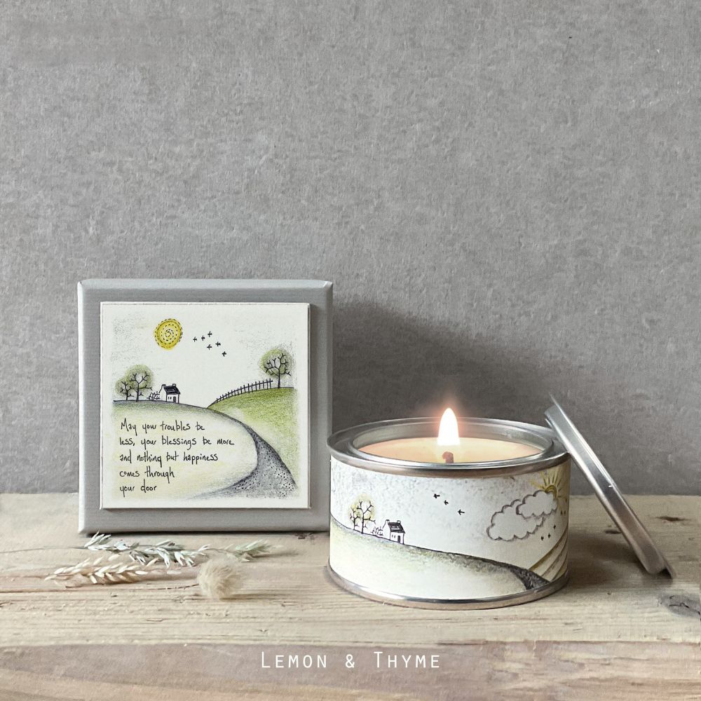 Candle in a tin with a decorative label on a wooden surface, featuring the brand 'Lemon & Thyme'.