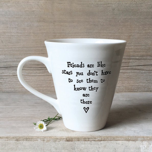White mug with a motivational quote on a wooden surface