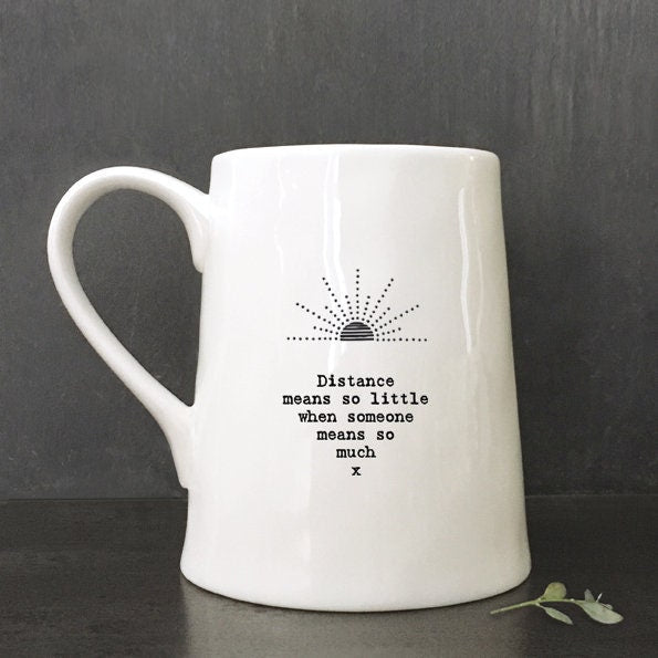 White mug with text and logo on a against a dark background
