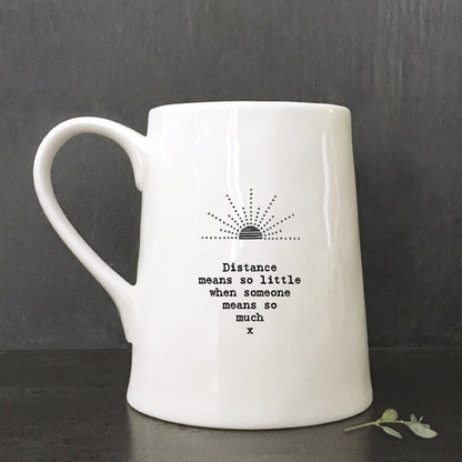 White mug with text and logo on a against a dark background