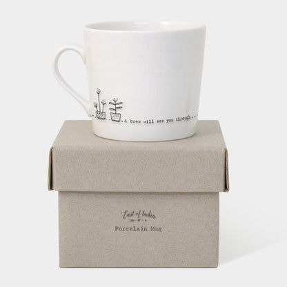 White mug with a black text and flower design and box on a white background