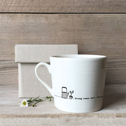 White mug with a design and text on a wooden surface
