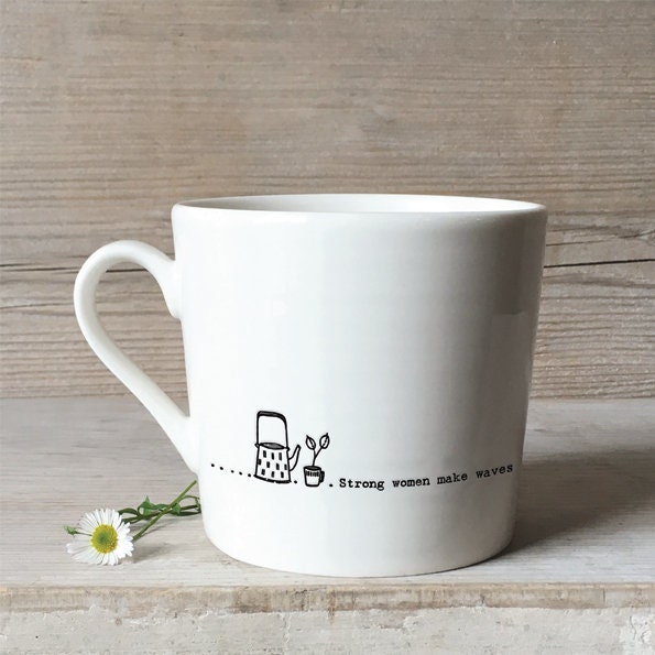 White mug with a design and text on a wooden surface