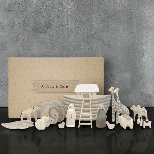 Set of decorative animal figurines and a boat on a dark surface with a neutral background