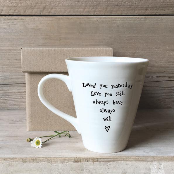 White mug with text and heart design in a gift box on a wooden background