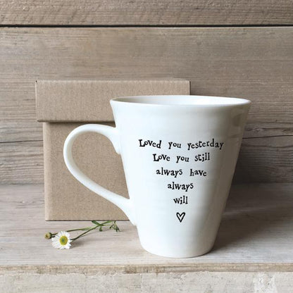 White mug with text and heart design in a gift box on a wooden background