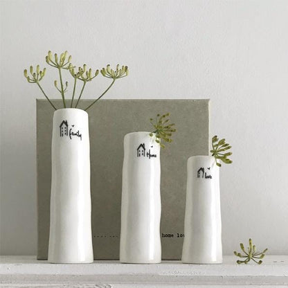Three white vases with decorative text and greenery on a light gray background