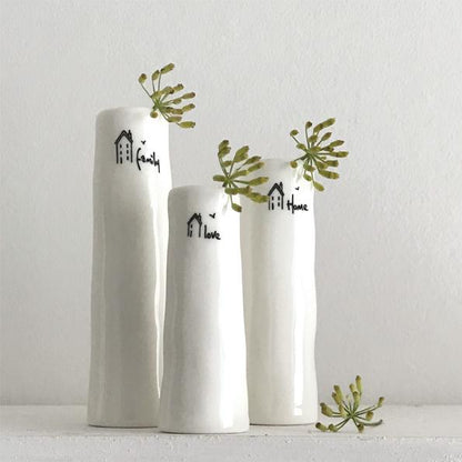 Three white vases with decorative text and greenery on a light gray background