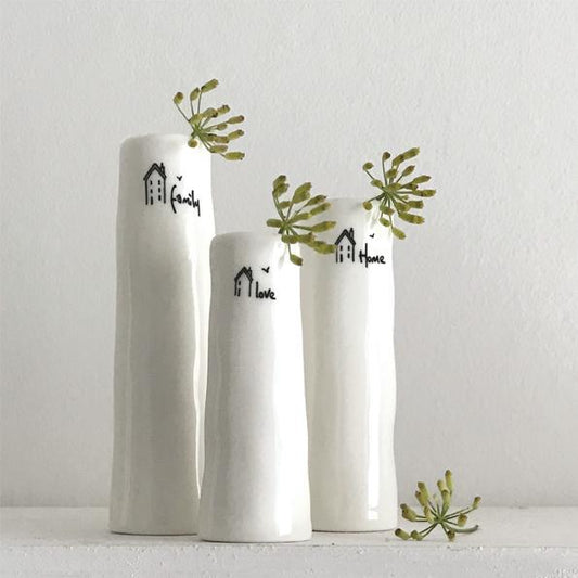 Three white vases with decorative text and greenery on a light gray background