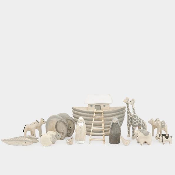 Set of decorative animal figurines and a boat on a dark surface with a neutral background