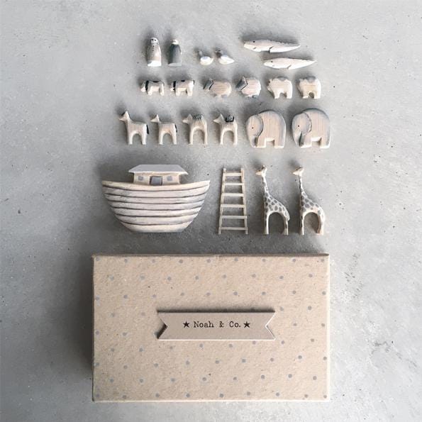 Set of ceramic toys including a boat, animals, and a ladder on a textured surface with 'Noah & Co.' branding.