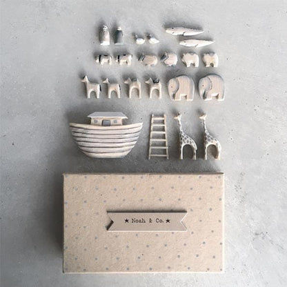 Set of ceramic toys including a boat, animals, and a ladder on a textured surface with 'Noah & Co.' branding.