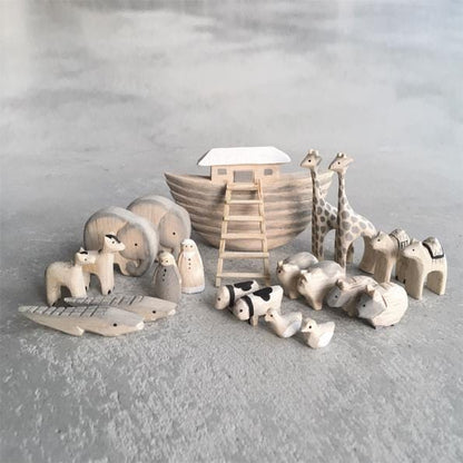 Wooden toy set including a Noah's ark and various animals on a gray surface